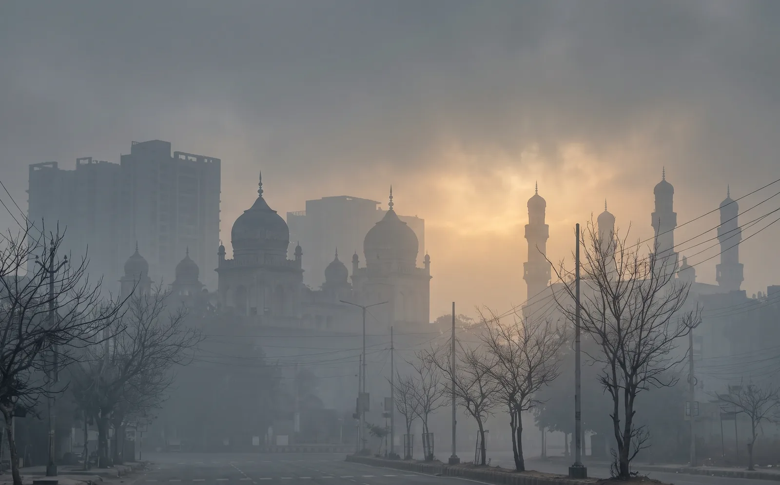 Hyderabad skyline with domes and minarets hidden in grey winter smog at sunrise